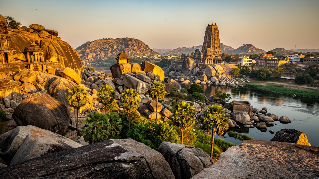 Dramatic Hampi landscape at golden hour — ancient temples among boulder-strewn hills along the Tungabhadra River